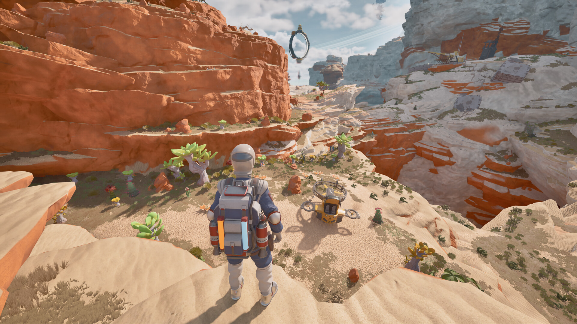 An explorer and a parked Wasp among orange canyon cliffs